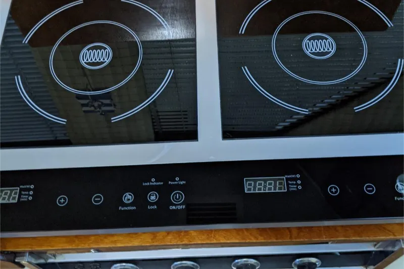 Slide: The Image of Modern induction cooktop on 1984 Gulfstar 49 Motor Yacht, featuring digital controls and dual burners. - 50