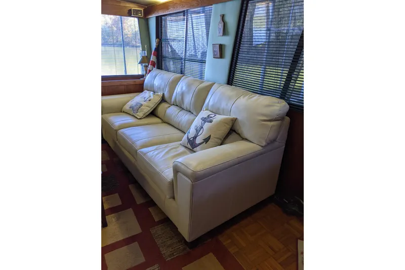 Slide: The Image of Luxurious interior of 1984 Gulfstar 49 Motor Yacht with plush white sofa and decorative pillows. - 56