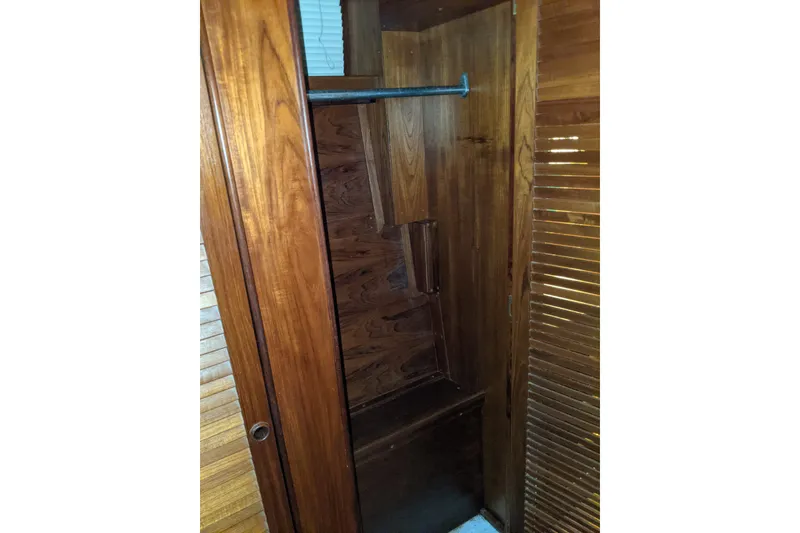 Slide: The Image of Wooden closet interior on 1984 Gulfstar 49 Motor Yacht, featuring hanging rod and shelves. - 57