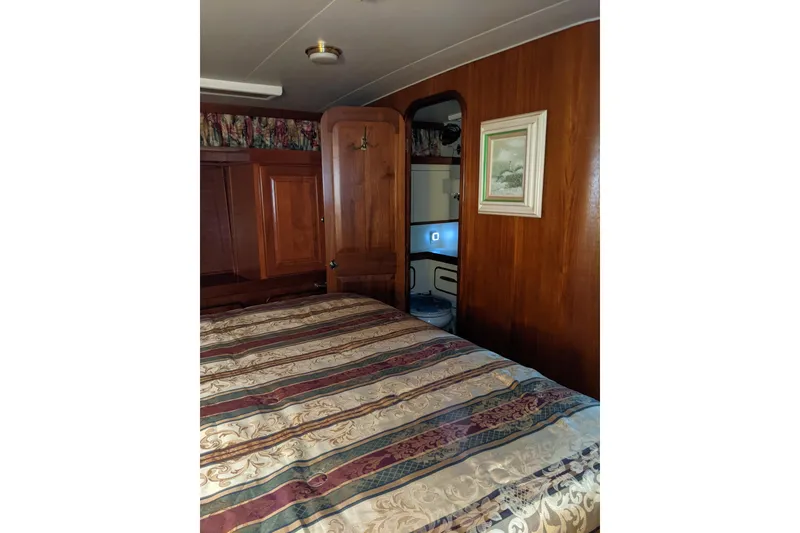 Slide: The Image of 1984 Gulfstar 49 Motor Yacht interior with wood paneling and patterned bedspread. - 58