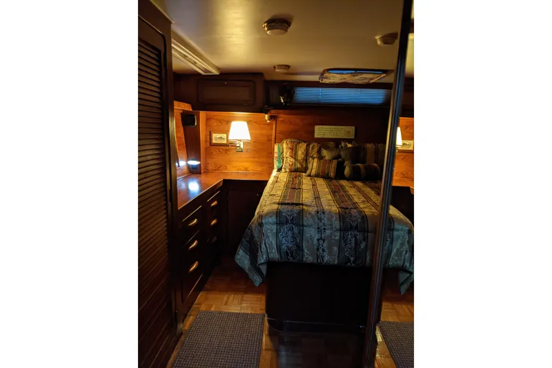 Slide: The Image of Cozy bedroom interior of 1984 Gulfstar 49 Motor Yacht with wood paneling and ambient lighting. - 60