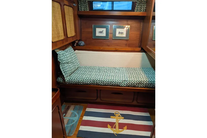 Slide: The Image of 1984 Gulfstar 49 Motor Yacht interior with cozy bed, nautical decor, and anchor-themed rug. - 66