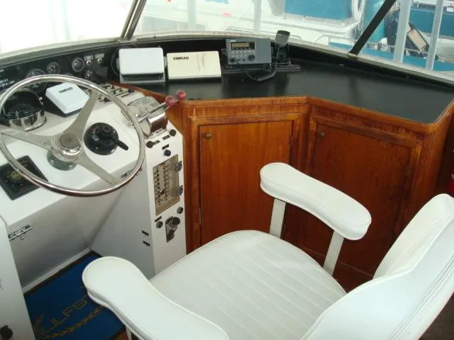Slide: The Image of 1984 Gulfstar 49 Motor Yacht helm with steering wheel, controls, and white captain's chair. - 7