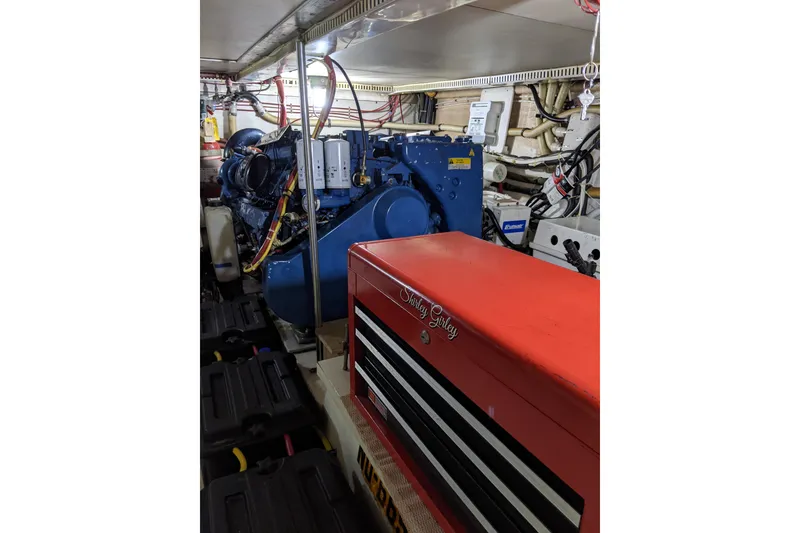 Slide: The Image of Engine room of 1984 Gulfstar 49 Motor Yacht with visible machinery and tool chest. - 77