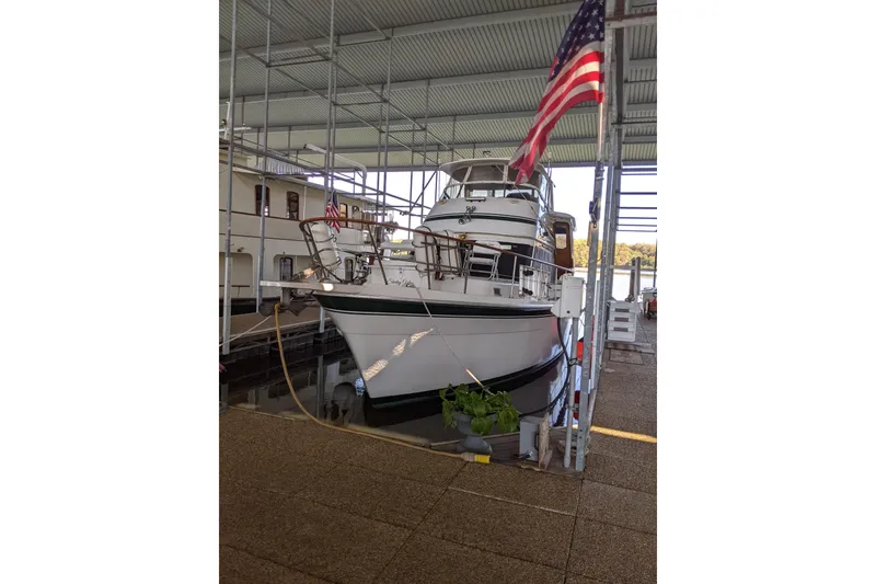 Slide: The Image of 1984 Gulfstar 49 Motor Yacht docked under a covered marina with American flag. - 93