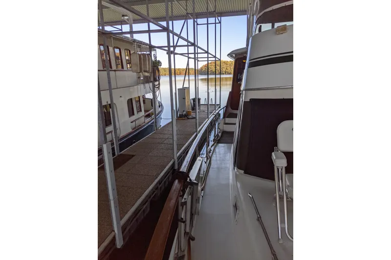 Slide: The Image of 1984 Gulfstar 49 Motor Yacht docked at marina with scenic lake view. - 95