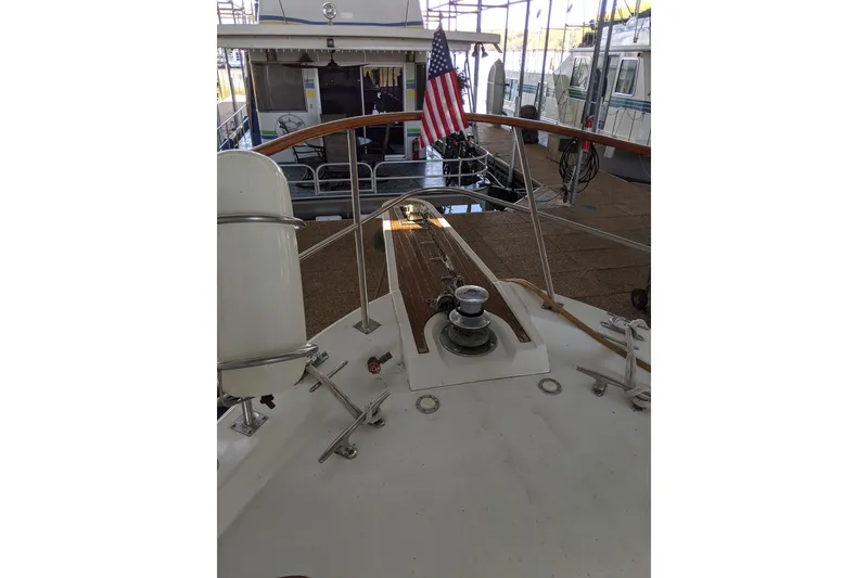 Slide: The Image of 1984 Gulfstar 49 Motor Yacht deck with American flag in marina setting. - 97