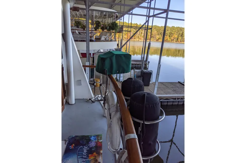 Slide: The Image of 1984 Gulfstar 49 Motor Yacht docked, featuring deck view with scenic lake backdrop. - 99