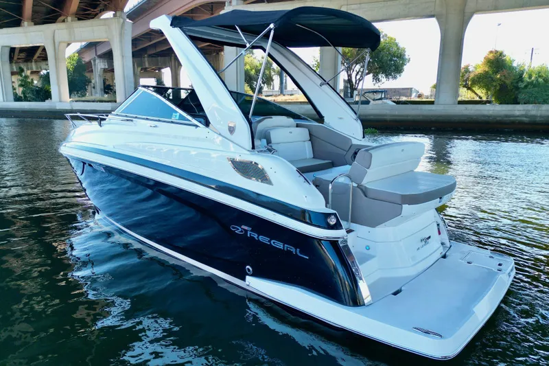 The Image of 2017 Regal 28 Express boat on water under bridge, featuring sleek design and spacious seating. - 0