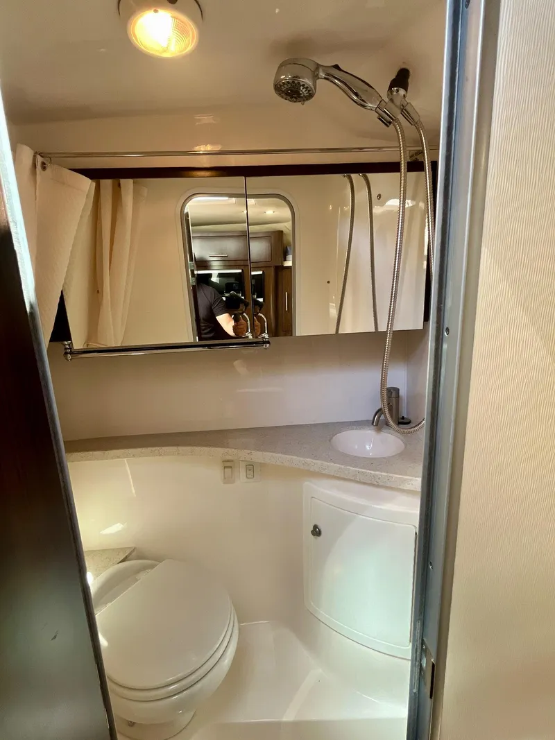 Slide: The Image of 2017 Regal 28 Express boat bathroom with shower, sink, and mirror. - 16