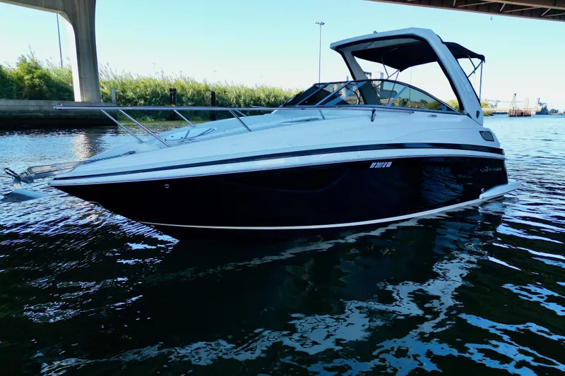 Slide: The Image of 2017 Regal 28 Express boat on water under a bridge, sleek design. - 2