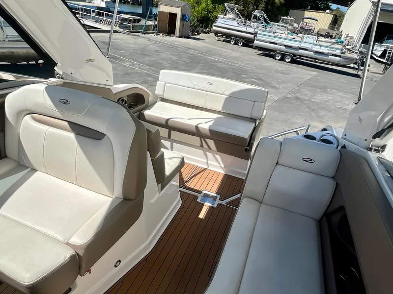 Slide: The Image of 2017 Regal 28 Express boat interior with beige seating and wood flooring. - 7