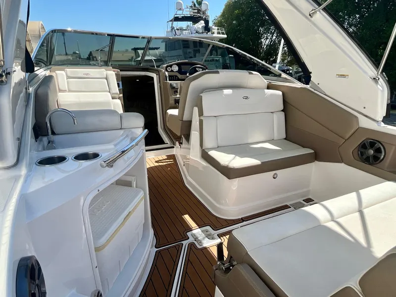 Slide: The Image of 2017 Regal 28 Express boat interior with white seating and wood flooring. - 9