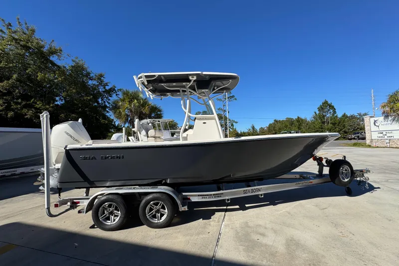 Slide: The Image of 2022 Sea Born LX22 Center Console boat on trailer, parked outdoors under clear blue sky. - 10