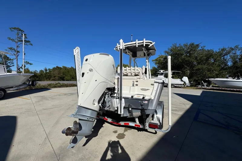 Slide: The Image of 2022 Sea Born LX22 Center Console boat with powerful outboard motor in a sunny marina. - 13