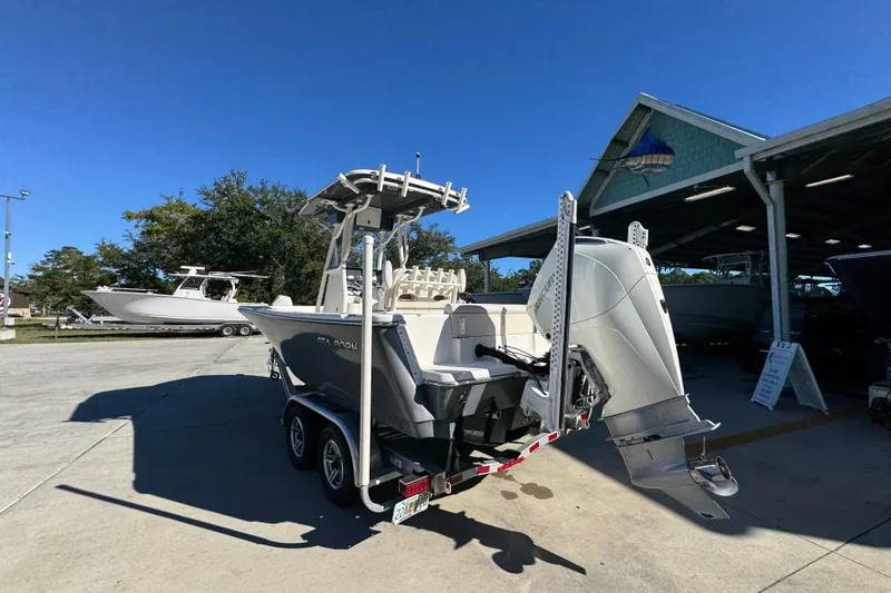 Slide: The Image of 2022 Sea Born LX22 Center Console boat on trailer, parked outdoors under clear blue sky. - 16