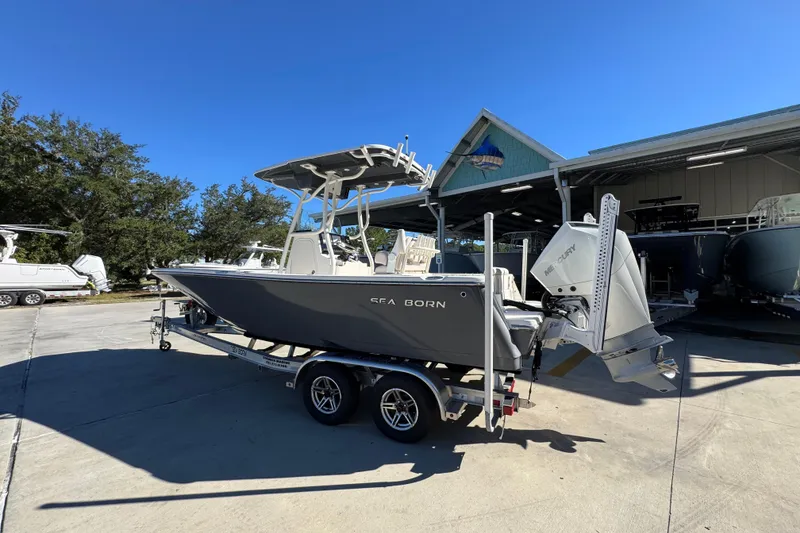 Slide: The Image of 2022 Sea Born LX22 Center Console boat on trailer under clear blue sky. - 17
