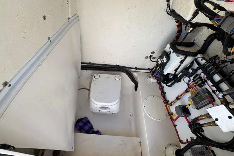 Slide: The Image of 2022 Sea Born LX22 Center Console boat interior with wiring and portable toilet. - 27