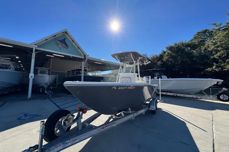 Slide: The Image of 2022 Sea Born LX22 Center Console boat on trailer under bright sun. - 4