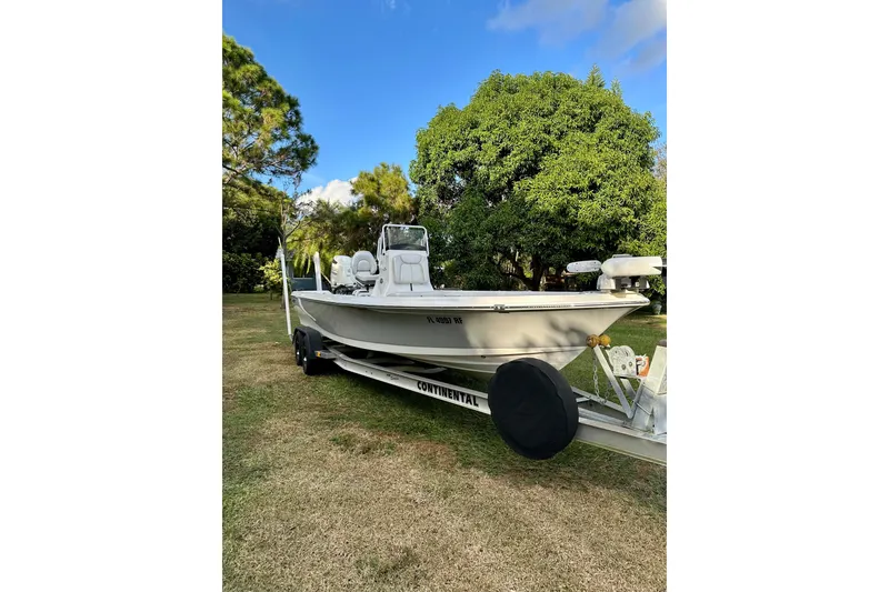 The Image of 2017 Blue Wave 2400 PureBay boat on trailer, parked on grass with trees in background. - 0