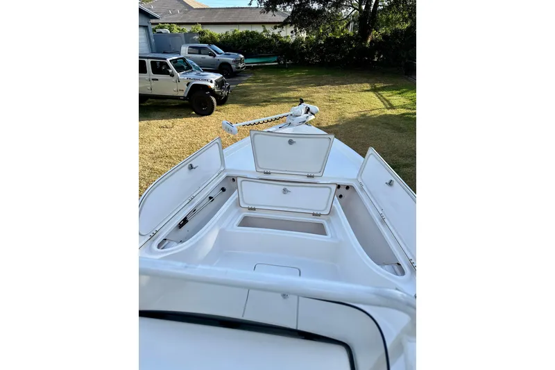 Slide: The Image of 2017 Blue Wave 2400 PureBay boat with open storage compartments, parked on grass. - 10