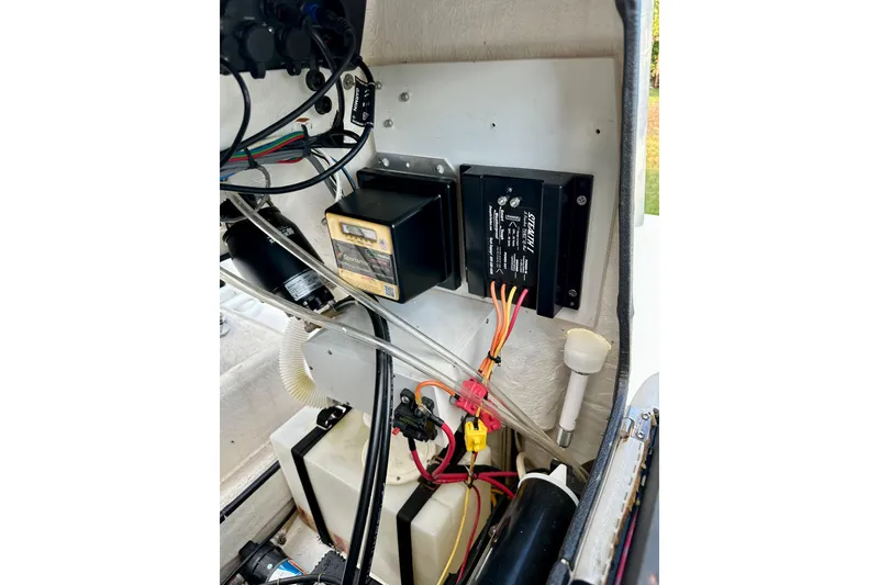 Slide: The Image of Electrical components inside a 2017 Blue Wave 2400 PureBay boat, featuring wiring and control boxes. - 18