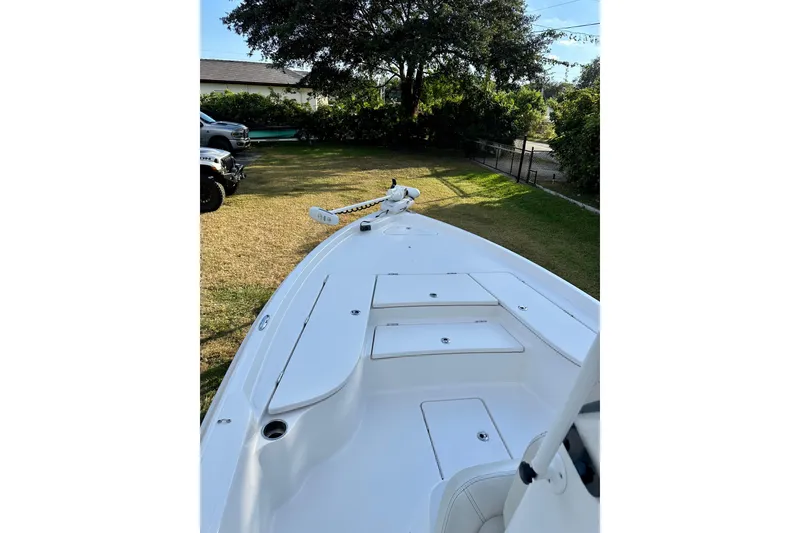 Slide: The Image of 2017 Blue Wave 2400 PureBay boat on grass, showcasing sleek deck design. - 5