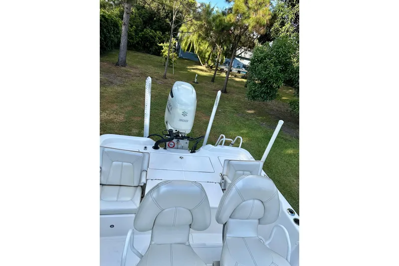 Slide: The Image of 2017 Blue Wave 2400 PureBay boat with Suzuki engine, parked on grass. - 6