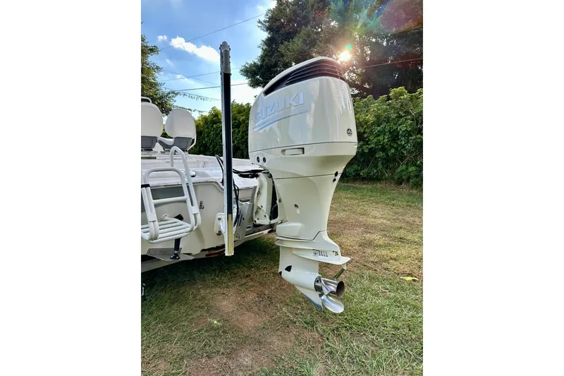 Slide: The Image of 2017 Blue Wave 2400 PureBay boat with Suzuki outboard motor in a grassy area. - 8