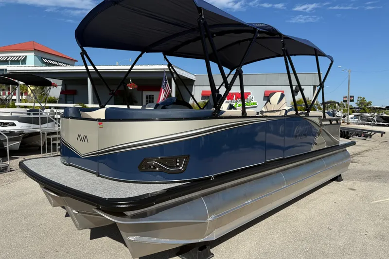 The Image of 2026 Avalon 2385 LSZ Quad Lounger Tri Toon boat with canopy, parked outdoors. - 1