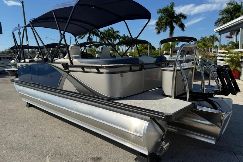 Slide: The Image of 2026 Avalon 2385 LSZ Quad Lounger Tri Toon boat with canopy, parked outdoors. - 7