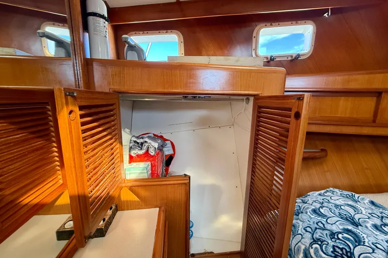 Slide: The Image of Interior of 1997 Offshore Yachts 48 Sedan with wooden cabinetry and storage space. - 18