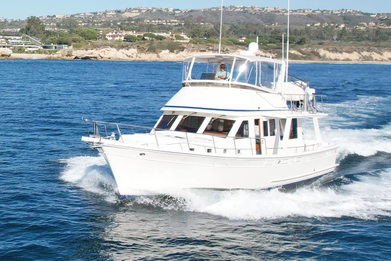 Slide: The Image of Offshore Yachts 48 Sedan 1997 cruising on blue ocean near scenic coastline. - 2