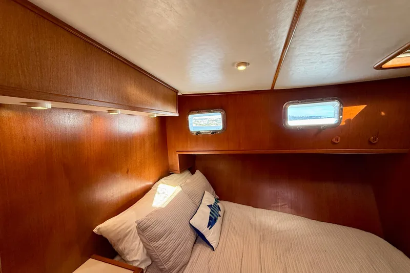 Slide: The Image of Cozy cabin interior of 1997 Offshore Yachts 48 Sedan with wooden paneling and porthole windows. - 25