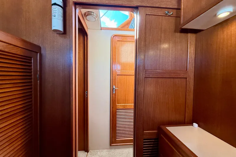 Slide: The Image of Interior of 1997 Offshore Yachts 48 Sedan, featuring wooden cabinetry and a doorway. - 27