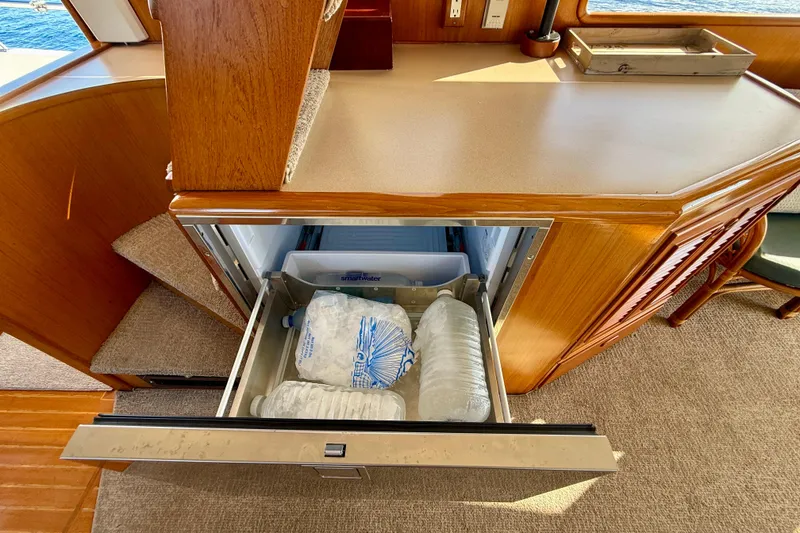 Slide: The Image of Open drawer refrigerator on 1997 Offshore Yachts 48 Sedan, containing ice and water bottles. - 48