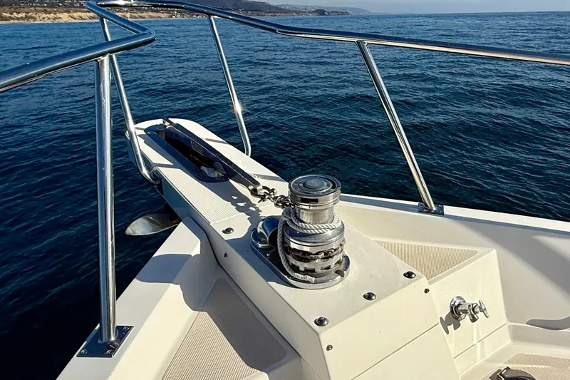 Slide: The Image of Bow of 1997 Offshore Yachts 48 Sedan with anchor and winch, on open sea. - 61