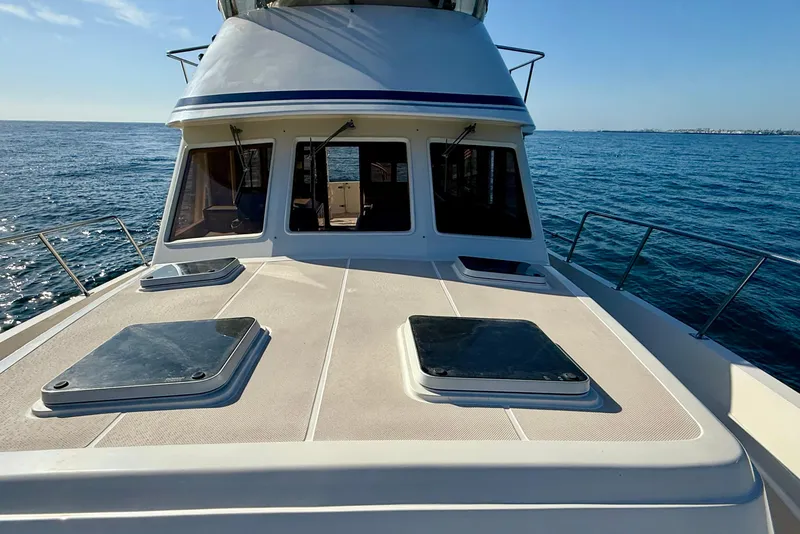 Slide: The Image of 1997 Offshore Yachts 48 Sedan on open water, showcasing deck and cabin windows. - 62