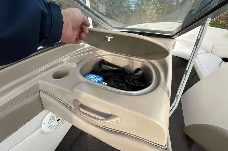Slide: The Image of 1999 Bayliner 1850 Capri LS boat storage compartment with open lid and visible contents. - 6