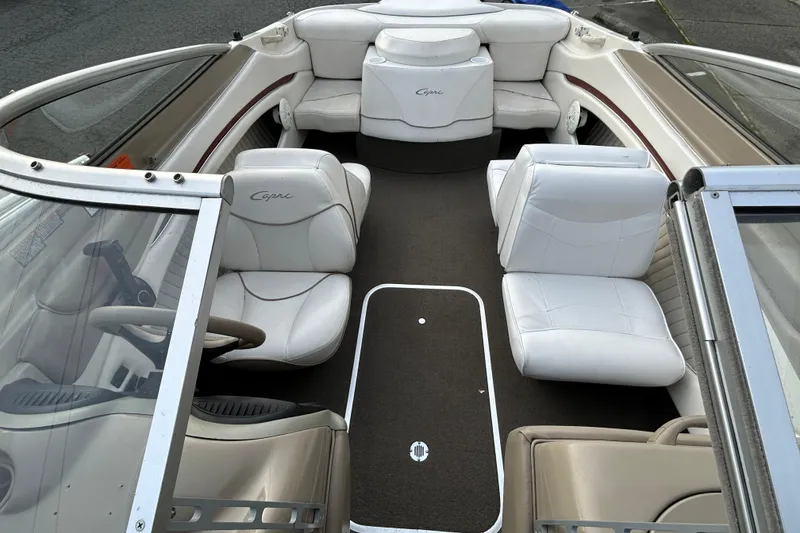 Slide: The Image of 1999 Bayliner 1850 Capri LS boat interior with white seating and steering wheel. - 9