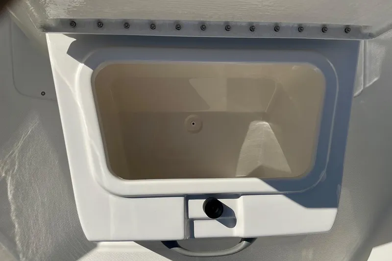 Slide: The Image of 2026 Bayliner Trophy T20CC storage compartment, open and empty, showcasing interior design. - 11