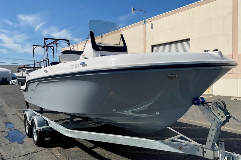 Slide: The Image of 2026 Bayliner Trophy T20CC boat on trailer, parked outdoors under clear sky. - 16