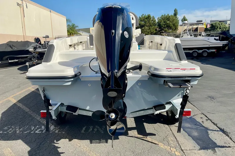 Slide: The Image of 2026 Bayliner Trophy T20CC boat with outboard motor, parked in a marina. - 2