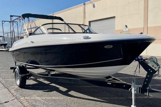 The Image of 2026 Bayliner VR4 Bowrider OB on trailer, parked outdoors, side view. - 0