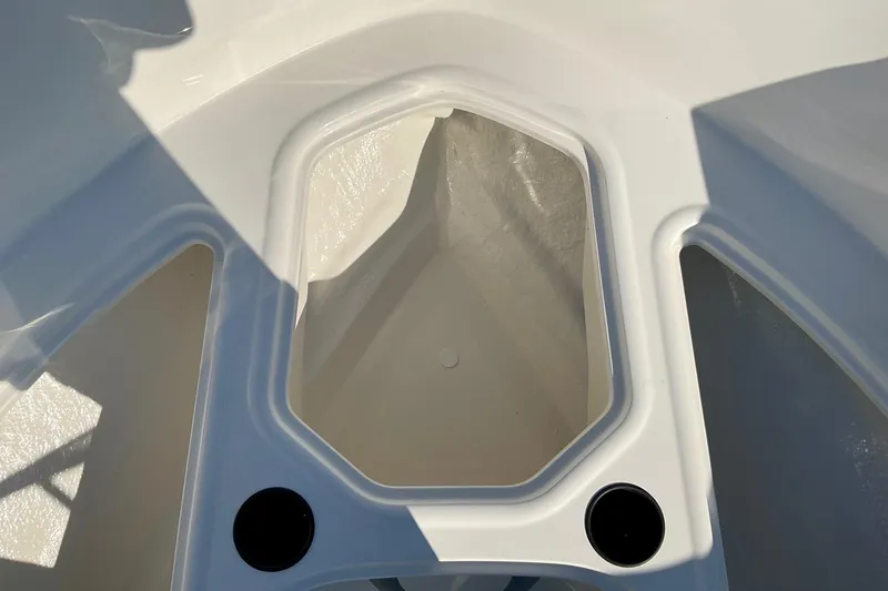 Slide: The Image of 2026 Bayliner VR4 Bowrider OB interior storage compartment, white finish, sunlight reflection. - 12