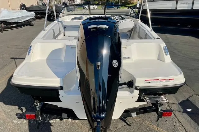 Slide: The Image of 2026 Bayliner VR4 Bowrider OB with outboard motor, rear view in a parking lot. - 5