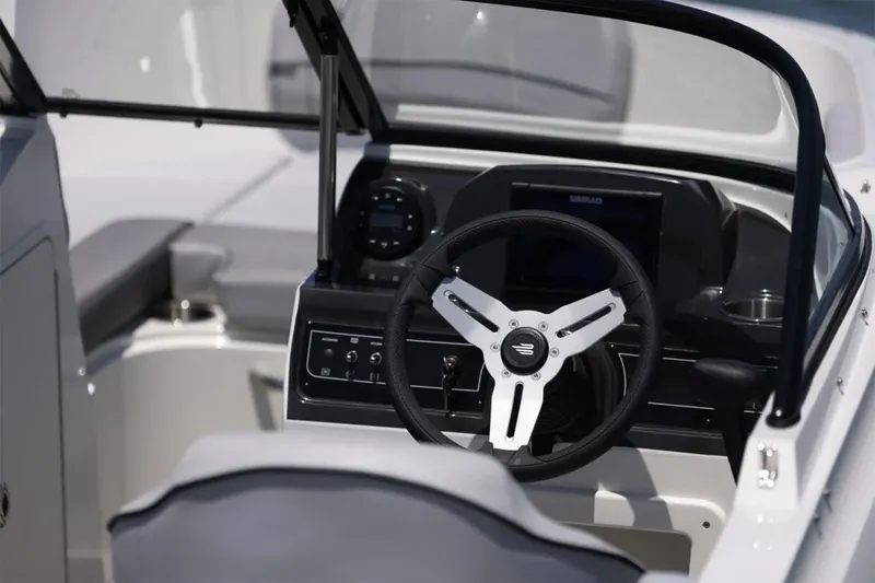 Slide: The Image of Manufacturer Provided Image: 2025 Bayliner VR4 Bowrider OB cockpit with steering wheel and dashboard controls. - 6