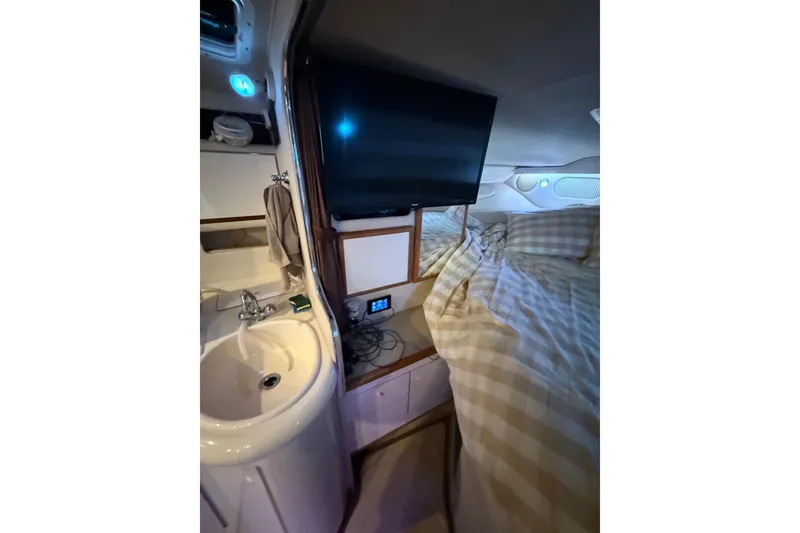 Slide: The Image of Interior of 1996 Sea Ray 330 Sundancer with sink, bed, and mounted TV. - 11