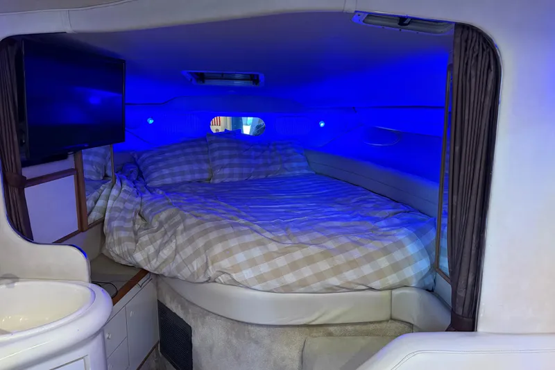 Slide: The Image of Interior cabin of 1996 Sea Ray 330 Sundancer with bed and ambient blue lighting. - 13