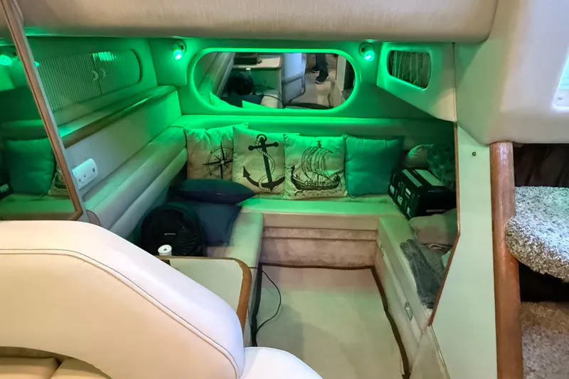 Slide: The Image of Interior of 1996 Sea Ray 330 Sundancer with nautical-themed cushions and ambient green lighting. - 16
